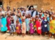 A large group of young girls wearing dresses made by St.Mary's and the MAAP Foundation in Uganda.