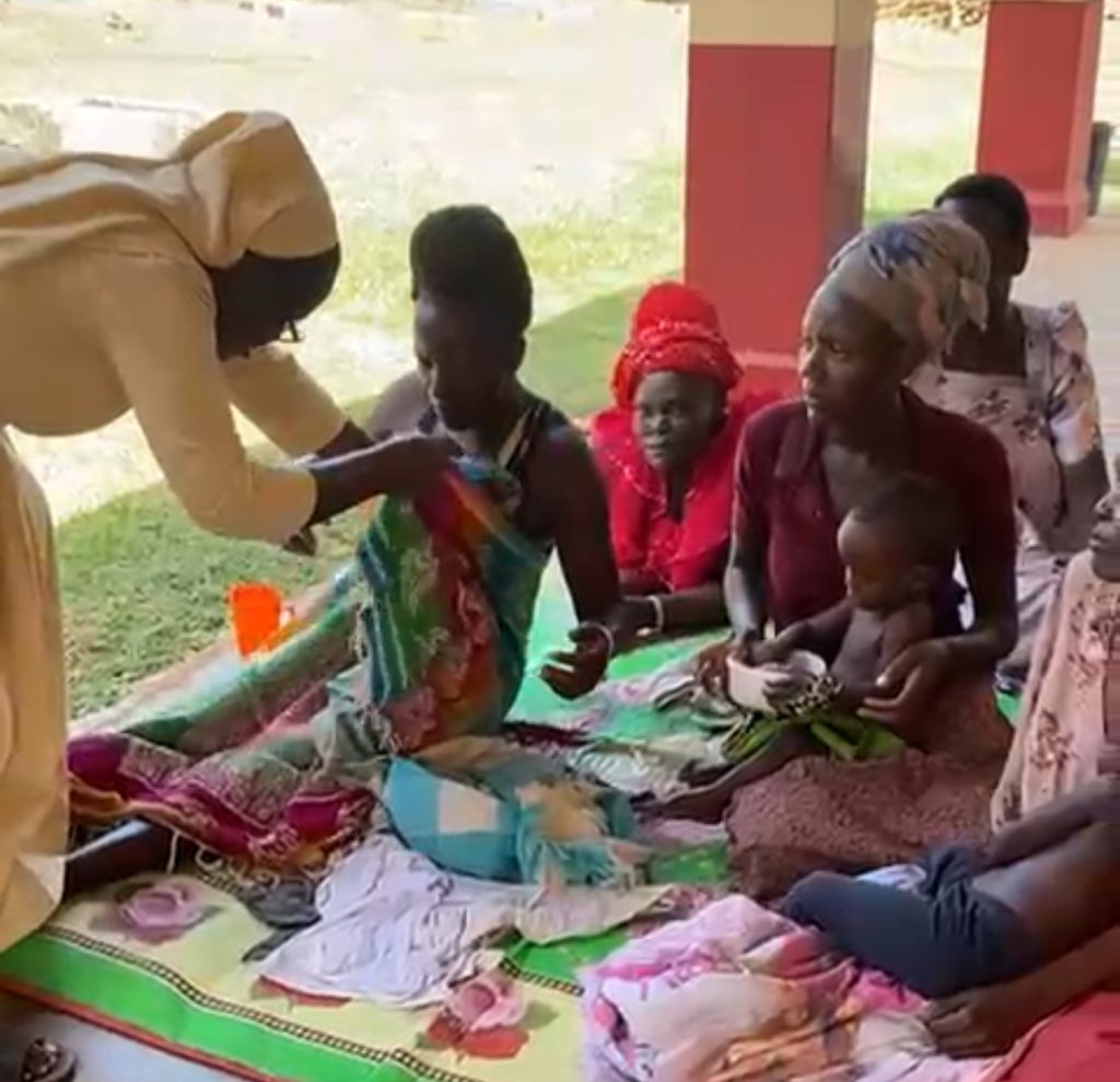 IMG_3887 A nurse in Uganda helps mothers and children pick out dresses donated by the MAAP Foundation.